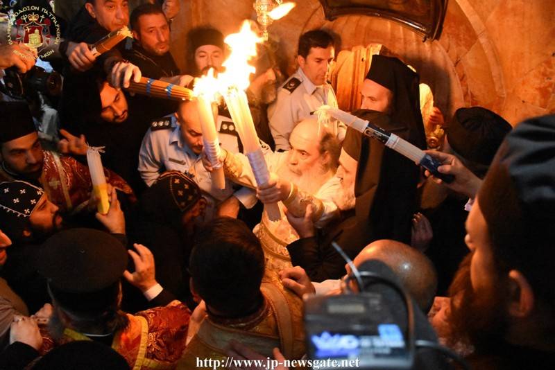 Ο Πατριάρχης Ἱεροσολύμων μεταδίδει το Άγιο Φως με τις λαμπάδες.