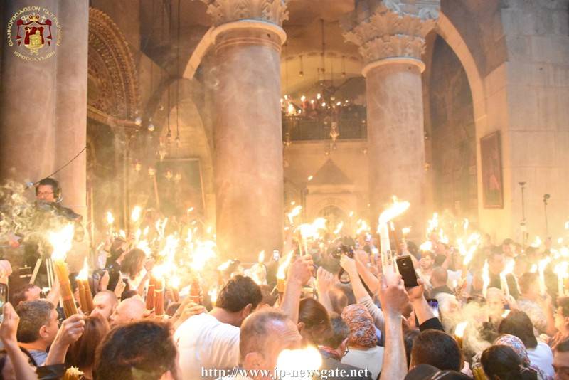 Το Αγιον Φως μεταδίδεται σε όλους τούς πιστούς στο Ναό.